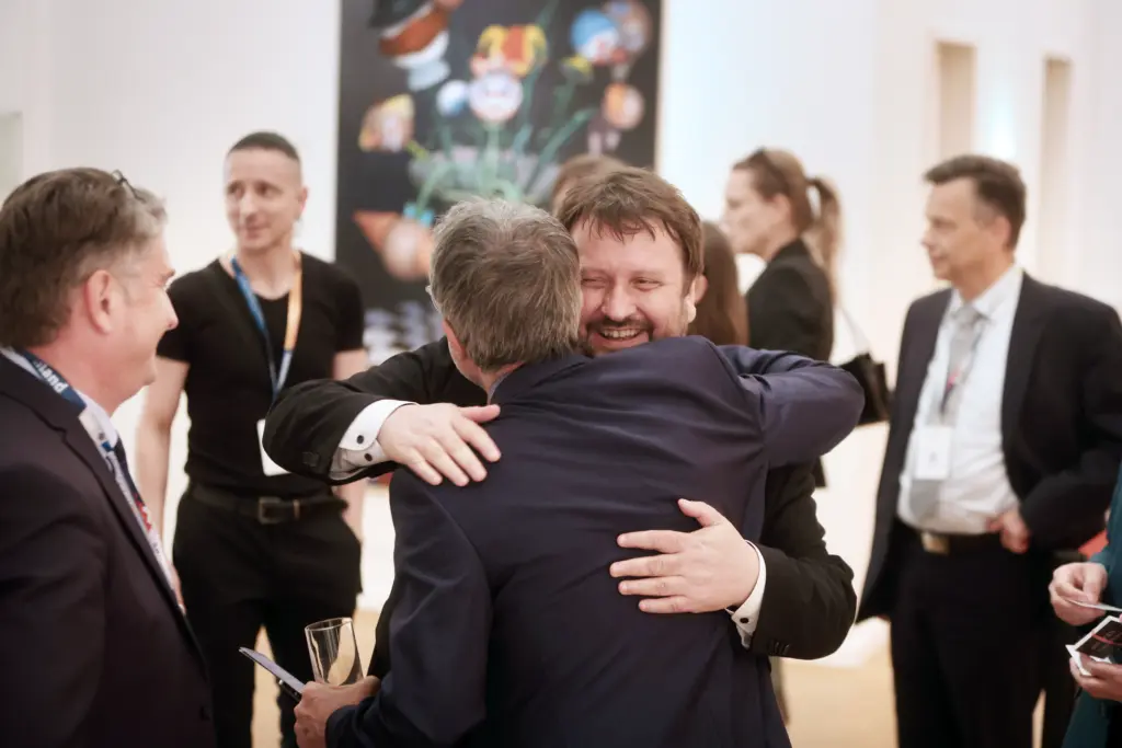 Dr. Fabian Magerl und Jean-Pierre Feuillet umarmen sich herzlich beim Get-together in der Kunsthalle der Sparkasse Leipzig im Rahmen des 3. Deutsch-Französischen Wirtschaftskongresses Mitteldeutschland (LPZ26). Foto: Anja Jungnickel