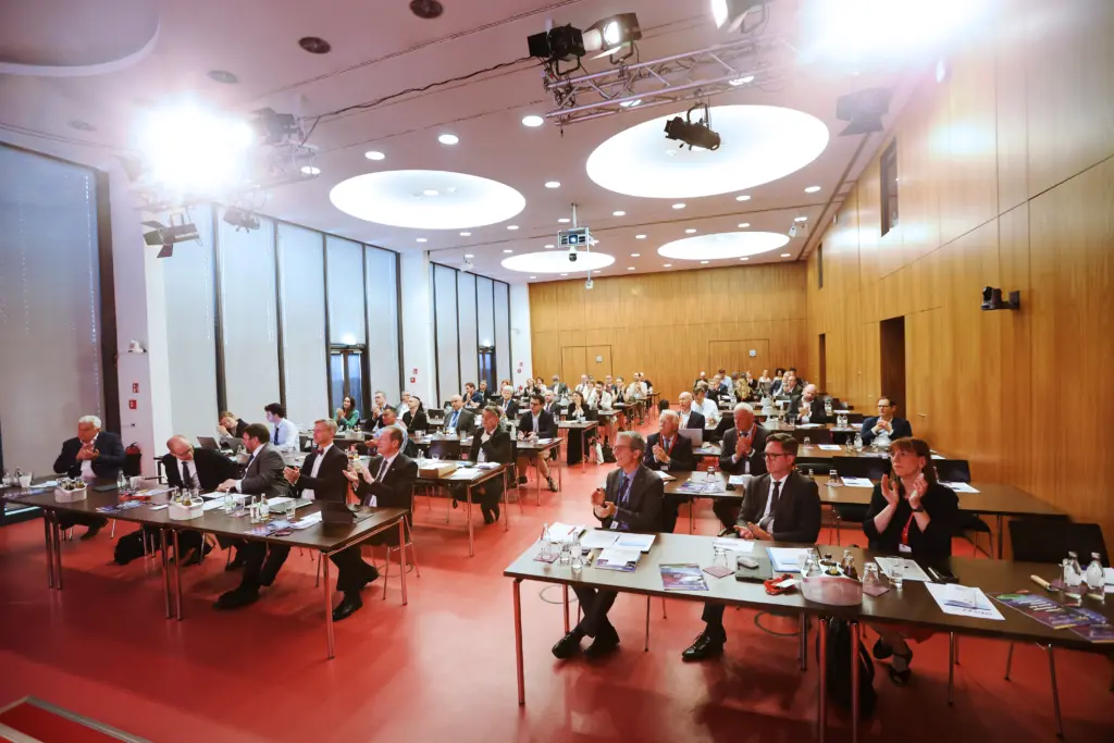 Das applaudierende Publikum sitzt im modernen, holzvertäfelten Kongresssaal auf dem Mediencampus Villa Ida in Leipzig beim 3. Deutsch-Französischen Wirtschaftskongress Mitteldeutschland (LPZ26). Foto: Anja Jungnickel