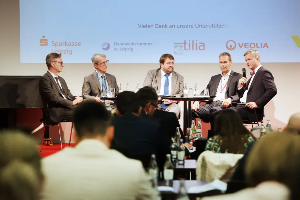 Eine hochkarätig besetzte Podiumsdiskussion mit Dr. Andreas Handschuh und weiteren Teilnehmern vor dem Sponsorenhintergrund auf dem 3. Deutsch-Französischen Wirtschaftskongress Mitteldeutschland (LPZ26) im Mediencampus Villa Ida in Leipzig. Foto: Anja Jungnickel