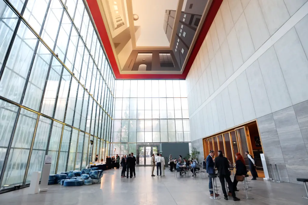 Blick in das lichtdurchflutete, weite Foyer des Museums der bildenden Künste Leipzig (MdbK) mit großer Glasfront und Deckenkunst während des Ausklangs des 3. Deutsch-Französischen Wirtschaftskongresses Mitteldeutschland (LPZ26). Foto: Anja Jungnickel