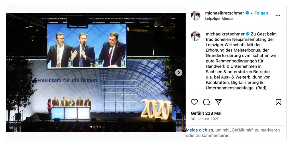 Screenshot eines Instagram-Beitrags von Sachsens Ministerpräsident Michael Kretschmer. Das Eventfoto zeigt die große beleuchtete Bühne beim Neujahrsempfang der Leipziger Wirtschaft in der Leipziger Messe mit dem Schriftzug "2020". Auf der Bühne stehen mehrere Personen an Stehpulten. Darüber hängt eine große Videoleinwand, auf der Kretschmer während einer Podiumsdiskussion mit dem Mikrofon in der Hand zu sehen ist.
