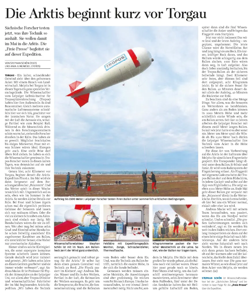 Zeitungsseite der Freien Presse mit der großen Schlagzeile "Die Arktis beginnt kurz vor Torgau". Der Artikel dokumentiert die Testvorbereitungen des Leibniz-Instituts für Troposphärenforschung (Tropos) für eine Arktis-Expedition. Die Seite enthält mehrere Fotos von Anja Jungnickel: Oben ein großformatiges Bild eines großen weißen und roten Fesselballons (Tropos-Ballon), der im Freien über einem Feld schwebt. Darunter befinden sich drei kleinere Detailfotos, die Forscher bei der Handhabung der Ausrüstung und im Feldbüro zeigen. Im Teaser steht der Fotonachweis "Von Stephan Schön (Text) und Anja Jungnickel (Fotos)".