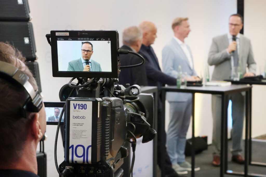 Professionelle Kongress- und Eventfotografie von Anja Jungnickel beim 15. Ostdeutschen Energieforum in Leipzig: Blick über eine professionelle Videokamera auf die Podiumsdiskussion der Speaker.